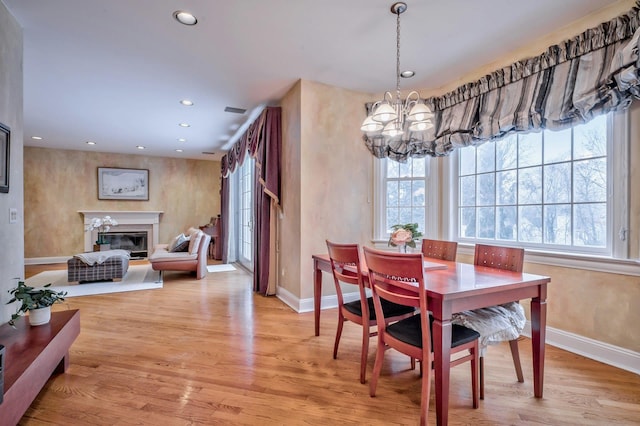 dining room featuring light wood-type flooring and a chandelier