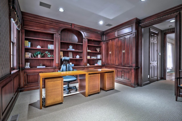 office space with wood walls, light colored carpet, and ornamental molding