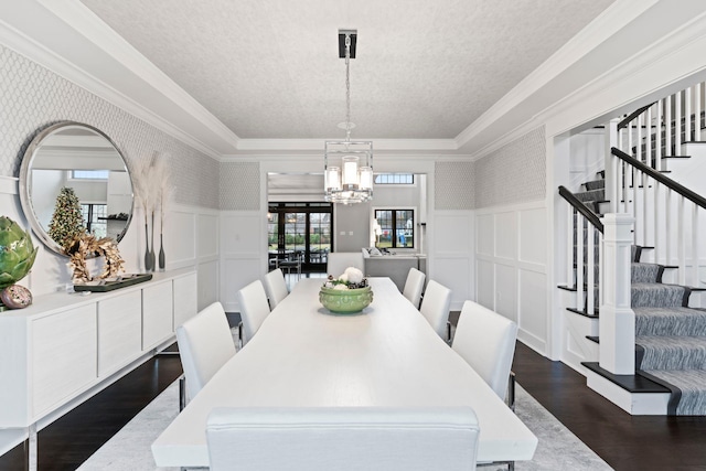 dining area with crown molding, dark hardwood / wood-style floors, a textured ceiling, and a notable chandelier