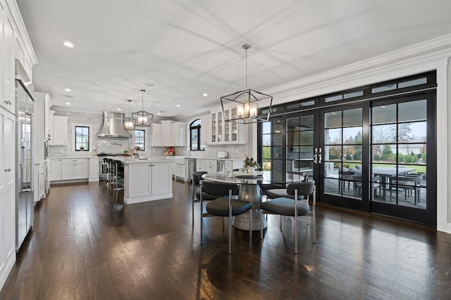 dining room with dark hardwood / wood-style flooring, crown molding, french doors, and a chandelier