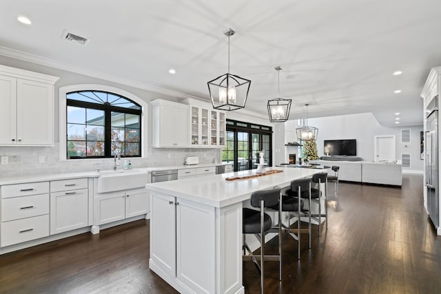 kitchen with sink, a center island, pendant lighting, and white cabinets