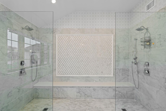 bathroom featuring a tile shower and lofted ceiling