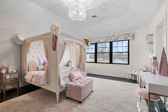 bedroom featuring dark wood-type flooring and a chandelier