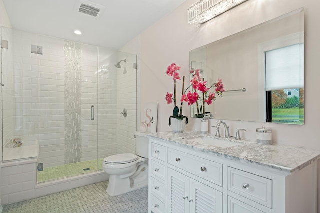 bathroom featuring vanity, a shower with door, and toilet