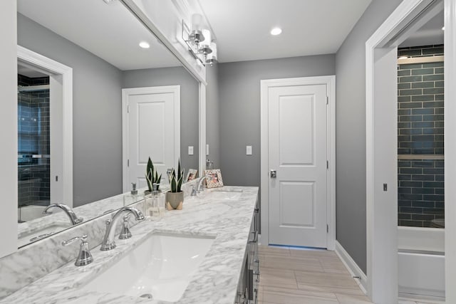 bathroom featuring tiled shower / bath and vanity