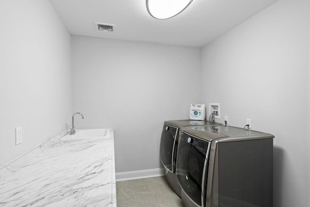 laundry area featuring washing machine and dryer and sink