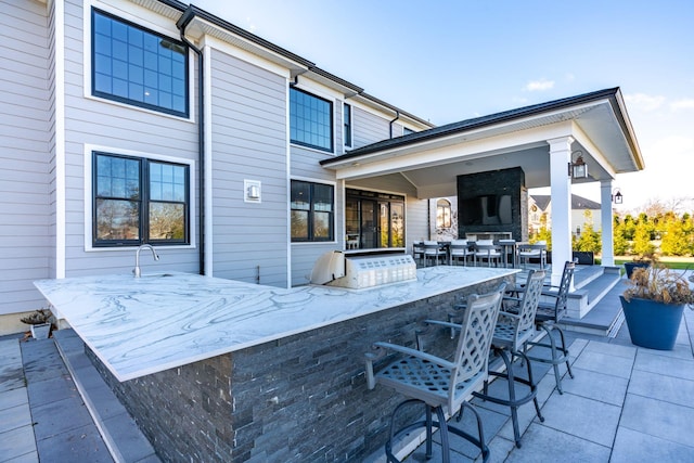 rear view of property with an outdoor bar and a patio area