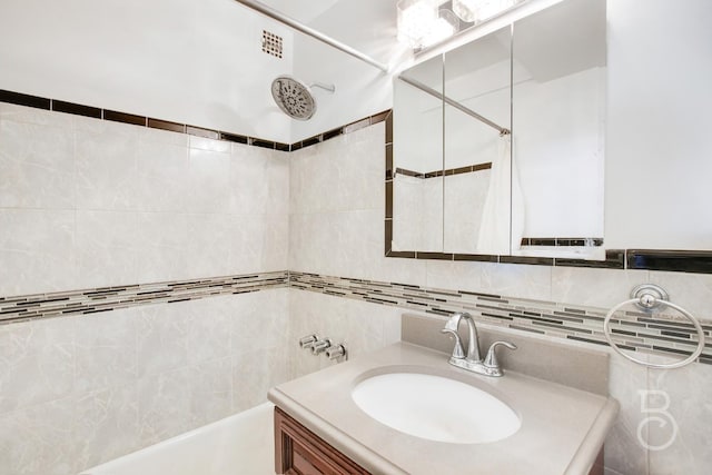 bathroom with tasteful backsplash, vanity, tile walls, and a tile shower