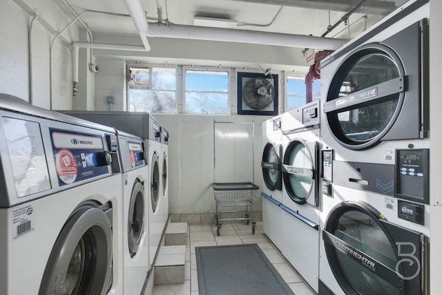 washroom featuring stacked washer and dryer, light tile patterned floors, and washing machine and clothes dryer