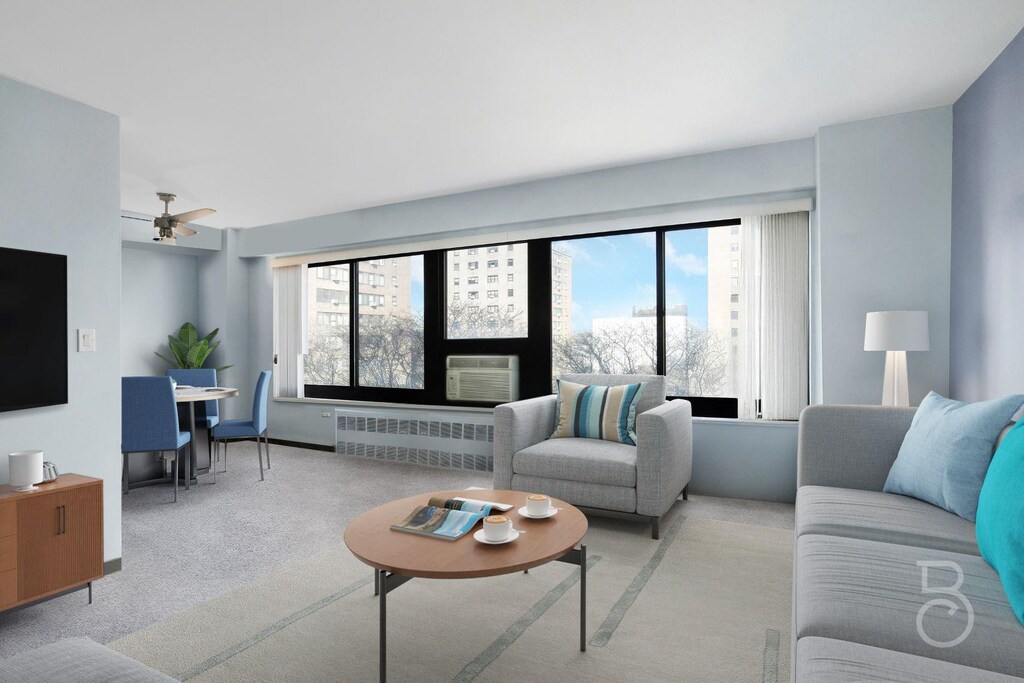 33-64 21st St Unit 8D, Astoria, NY 11106 - living room with radiator, plenty of natural light, light colored carpet, and ceiling fan