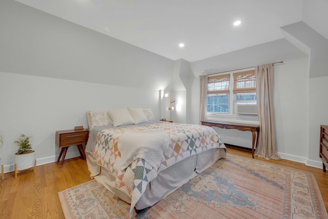 bedroom featuring light hardwood / wood-style floors and vaulted ceiling