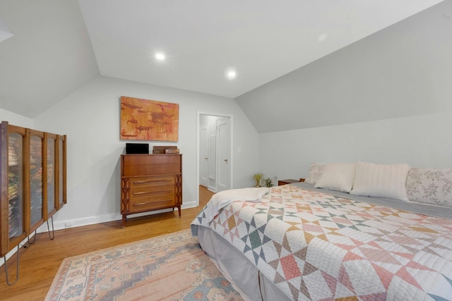 bedroom with hardwood / wood-style flooring and lofted ceiling