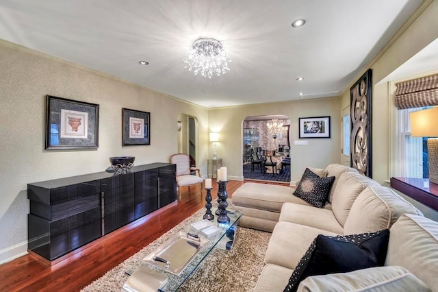 living room with dark hardwood / wood-style floors, an inviting chandelier, and ornamental molding