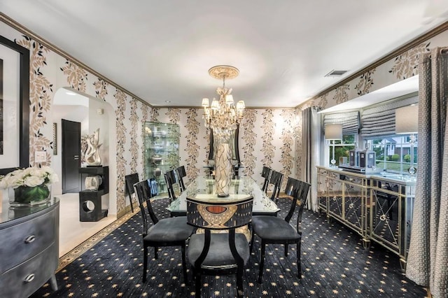 carpeted dining space featuring a chandelier and ornamental molding