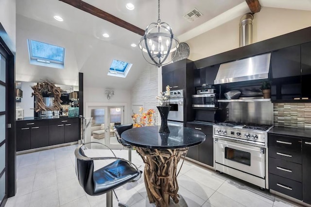 kitchen featuring a skylight, wall chimney exhaust hood, appliances with stainless steel finishes, beamed ceiling, and decorative light fixtures