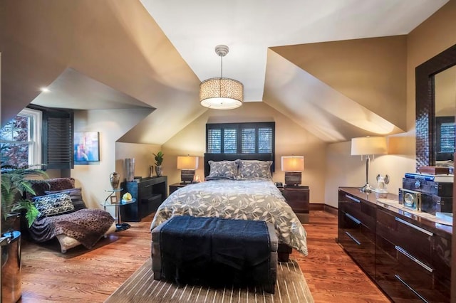 bedroom with hardwood / wood-style floors and vaulted ceiling