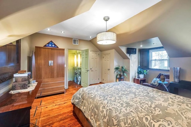 bedroom with wood-type flooring and vaulted ceiling