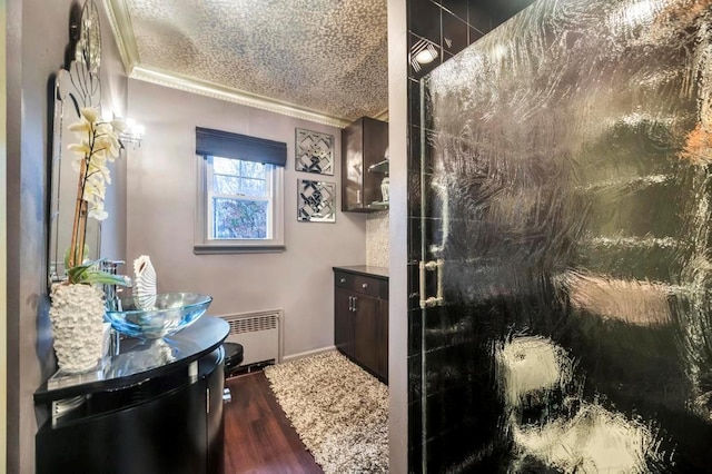 bathroom with crown molding, a textured ceiling, a shower with door, vanity, and hardwood / wood-style flooring