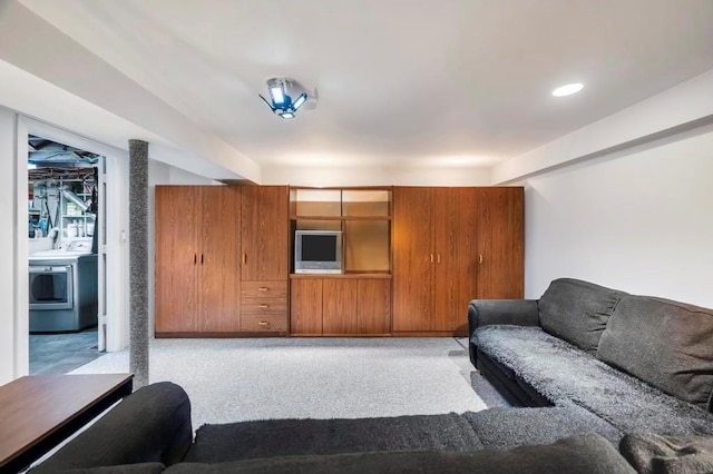 carpeted living room featuring washer / clothes dryer and wood walls