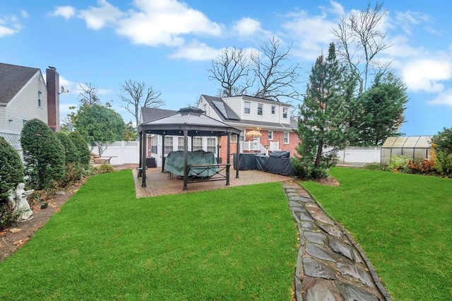 back of property featuring a gazebo, a yard, and an outdoor structure