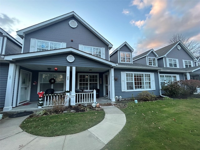 view of front of home with a porch and a lawn