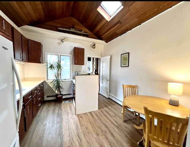 kitchen with hardwood / wood-style floors, vaulted ceiling with skylight, a baseboard radiator, white refrigerator, and wood ceiling