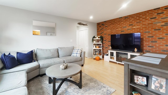 living room featuring hardwood / wood-style floors and brick wall