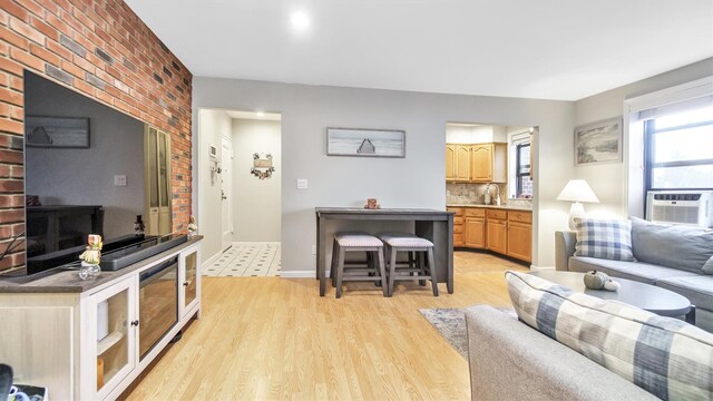 living room featuring light hardwood / wood-style flooring, cooling unit, and sink