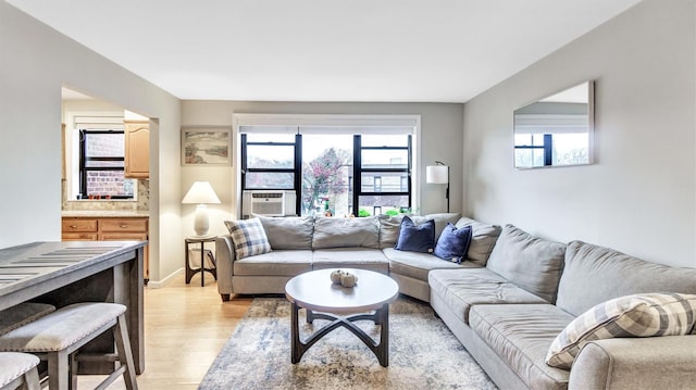 living room with cooling unit, a healthy amount of sunlight, and light hardwood / wood-style floors