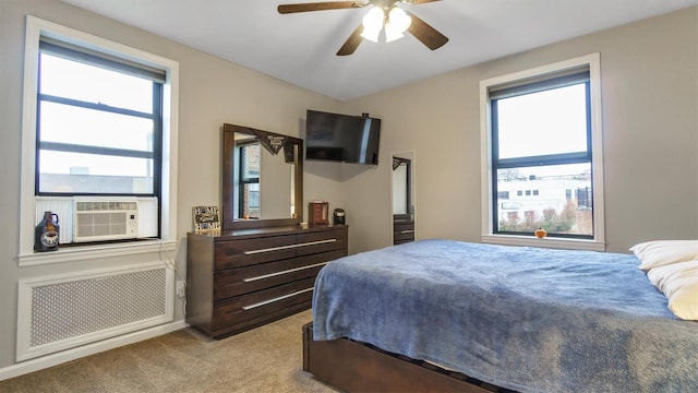 carpeted bedroom with multiple windows, ceiling fan, cooling unit, and radiator