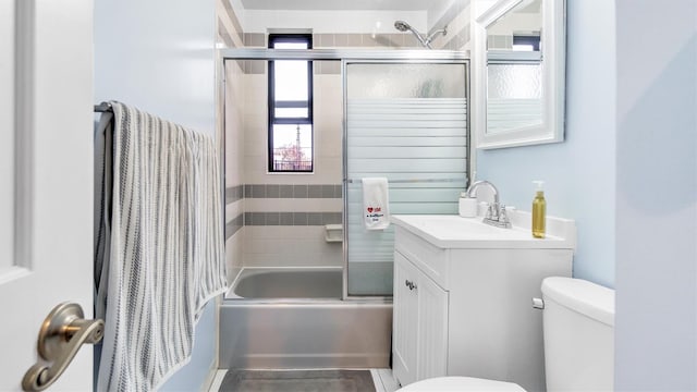 full bathroom featuring vanity, toilet, and bath / shower combo with glass door