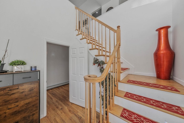 staircase featuring hardwood / wood-style flooring and baseboard heating