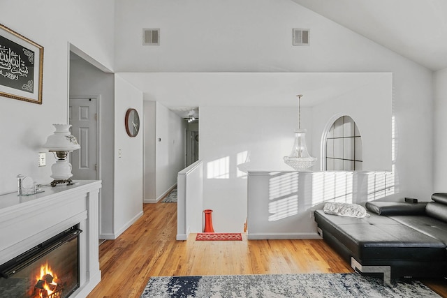 interior space featuring high vaulted ceiling and light hardwood / wood-style flooring