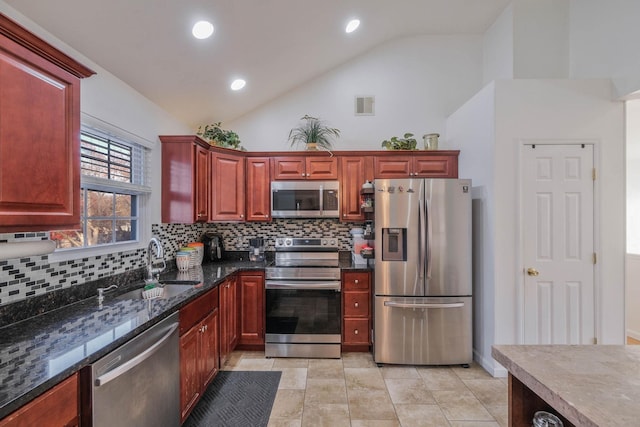 kitchen with high vaulted ceiling, sink, decorative backsplash, dark stone countertops, and stainless steel appliances