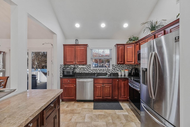 kitchen featuring appliances with stainless steel finishes, backsplash, vaulted ceiling, and sink