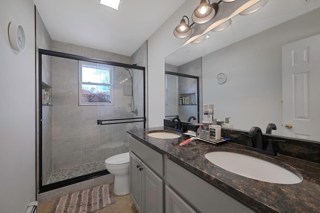 bathroom featuring baseboard heating, tile patterned flooring, toilet, a shower with door, and vanity