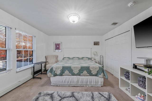 bedroom with light carpet, a closet, and baseboard heating