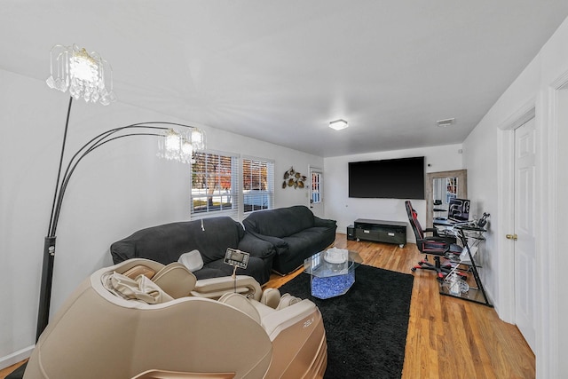 living room with hardwood / wood-style floors and a notable chandelier