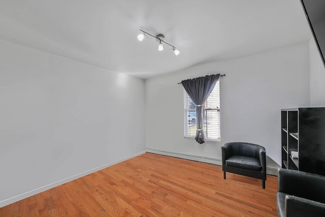 living area featuring a baseboard radiator and hardwood / wood-style flooring