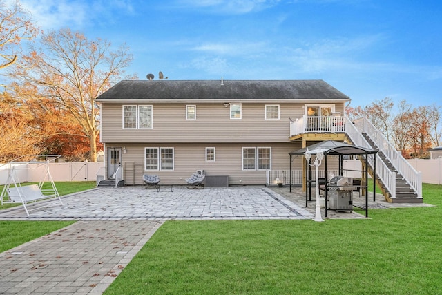 rear view of house featuring a gazebo, a lawn, and a patio