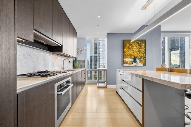 kitchen featuring a kitchen breakfast bar, tasteful backsplash, a healthy amount of sunlight, and appliances with stainless steel finishes