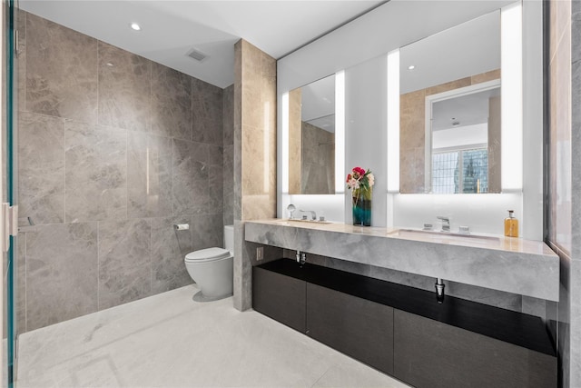 bathroom with vanity, toilet, and tile walls