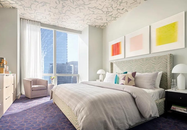 bedroom with floor to ceiling windows and dark carpet