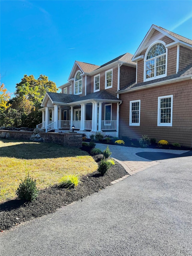 view of front facade with covered porch and a front yard