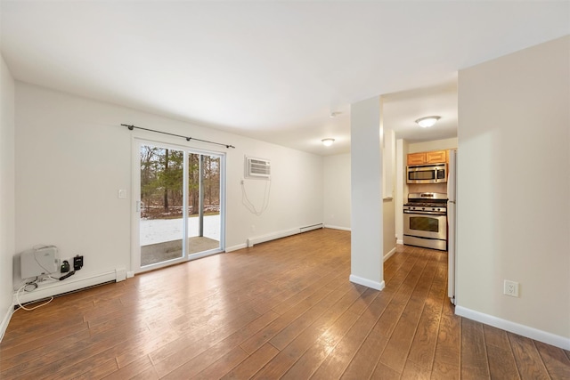 empty room featuring hardwood / wood-style floors, a wall mounted air conditioner, and baseboard heating