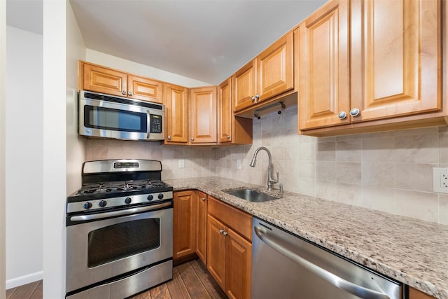 kitchen featuring dark wood-type flooring, light stone countertops, sink, and stainless steel appliances