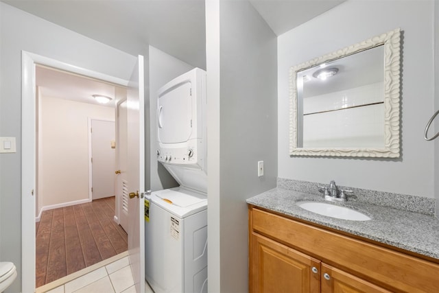 bathroom featuring hardwood / wood-style floors, vanity, and stacked washer / drying machine