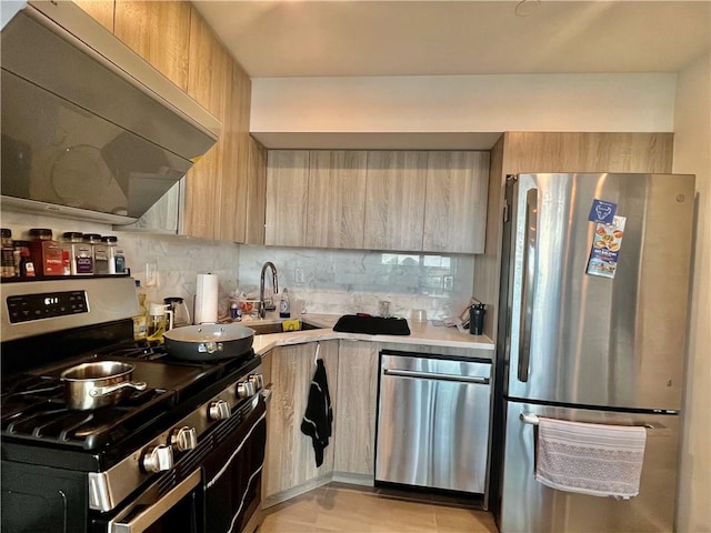 kitchen with sink, tasteful backsplash, light brown cabinetry, appliances with stainless steel finishes, and extractor fan