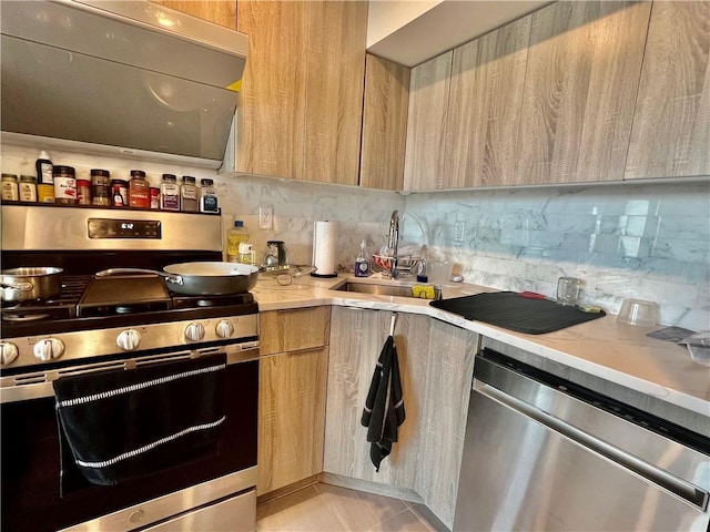 kitchen with appliances with stainless steel finishes, tasteful backsplash, sink, light brown cabinets, and light tile patterned floors