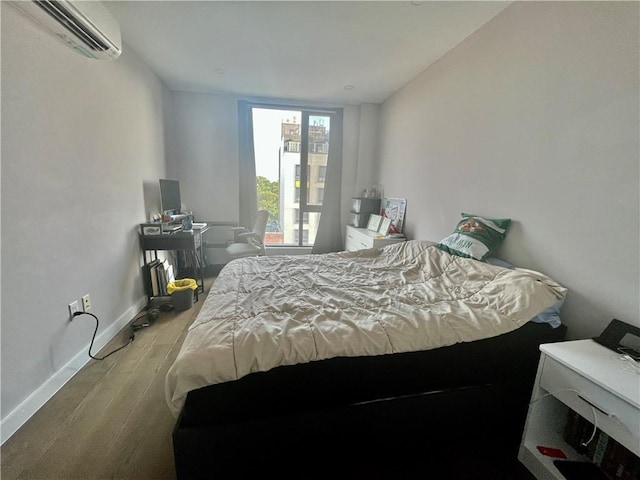 bedroom with hardwood / wood-style floors and a wall mounted AC